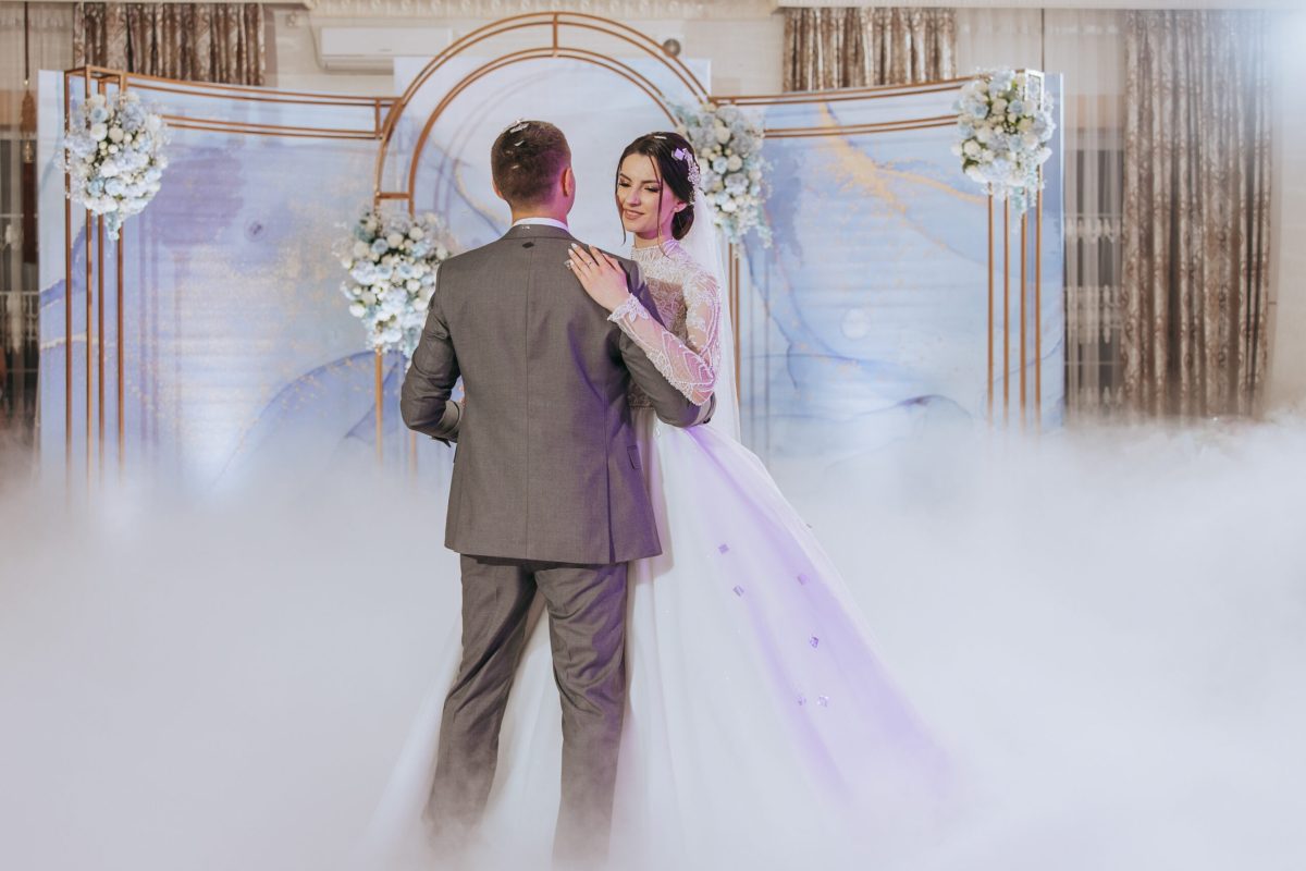 Vecteezy a bride and groom are dancing in front of a blue archway 48462240 scaled.jpg