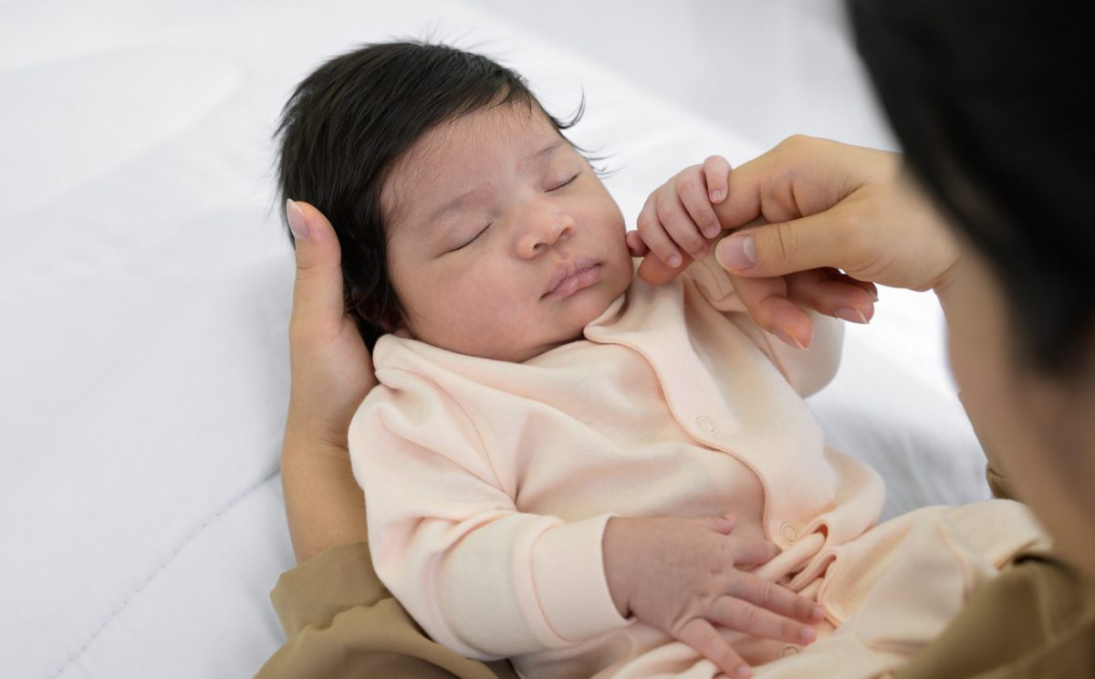Vecteezy mother touching cheek of newborn baby daughter on bed at 41508341 scaled.jpg