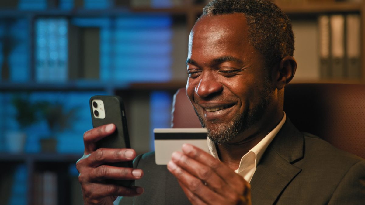 Vecteezy smiling african american businessman hold credit card remote 374711 scaled.jpg